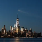 A SpaceX Falcon 9 rocket on the Starlink Group 10-49 mission passes by lower Manhattan and One World Trade Center just before dawn in New York City after launching from Cape Canaveral, Florida on Aug. 25, 2026, as seen from Hoboken, New Jersey. (Image credit: Getty Images)